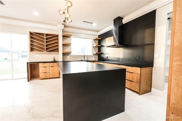 kitchen with a center island, wall chimney range hood, and sink