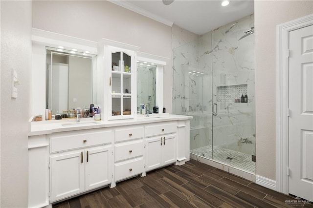 full bathroom featuring a marble finish shower, a sink, ornamental molding, and wood tiled floor