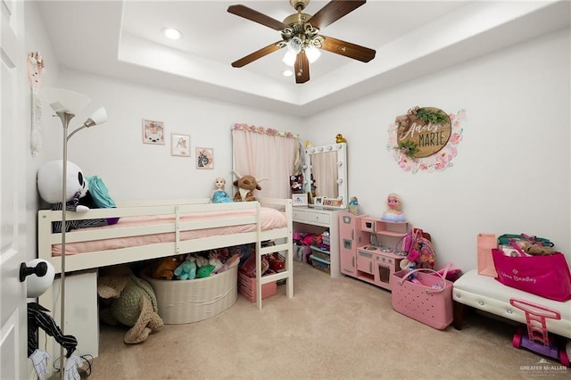 carpeted bedroom with recessed lighting, a tray ceiling, and ceiling fan