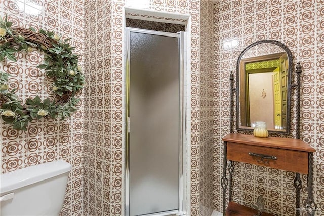 bathroom with a shower with shower door and toilet