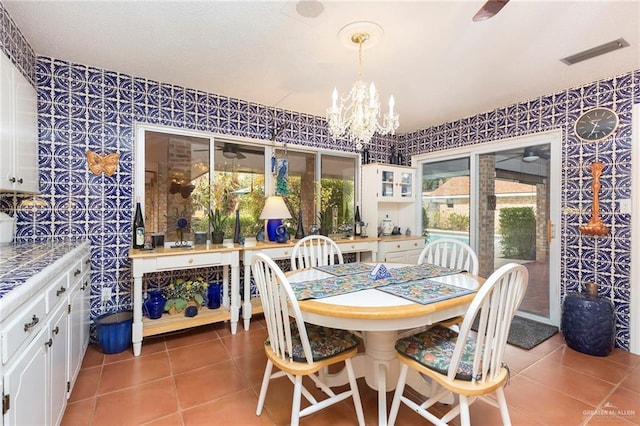 dining space with a chandelier and tile patterned floors