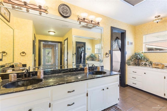 bathroom featuring tile patterned flooring, vanity, and a textured ceiling