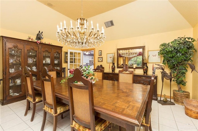 tiled dining room featuring a chandelier and vaulted ceiling