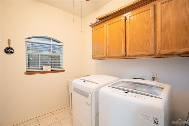 clothes washing area with cabinets, light tile patterned floors, and independent washer and dryer