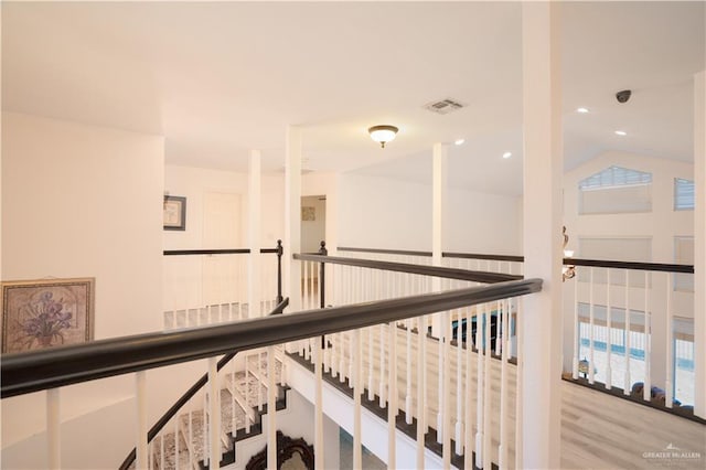 hallway with light hardwood / wood-style floors and vaulted ceiling