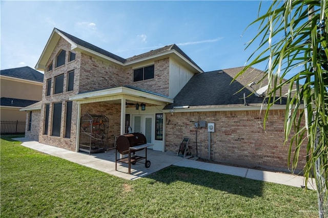 back of house with ceiling fan, a patio area, and a lawn