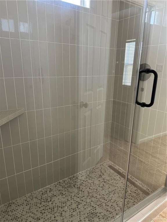 bathroom with a shower with door