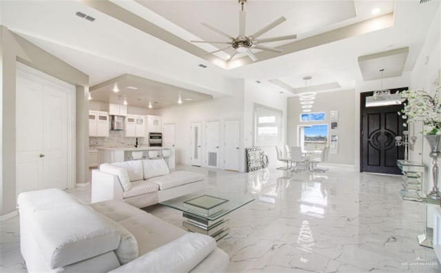 3011 E Ebano Ave, Hidalgo, TX 78557 - living room with a tray ceiling, a ceiling fan, light marble finish floors, and recessed lighting