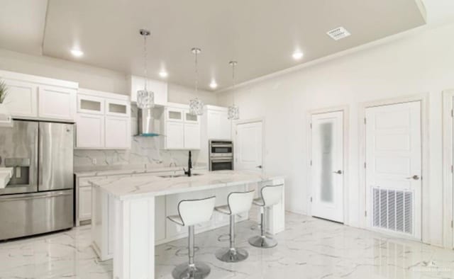 3011 E Ebano Ave, Hidalgo, TX 78557 - kitchen with appliances with stainless steel finishes, light marble finish flooring, recessed lighting, an island with sink, and white cabinetry