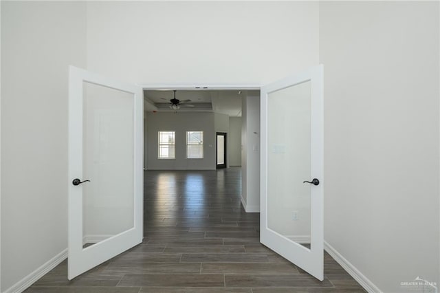 corridor featuring dark wood-style flooring, baseboards, and french doors