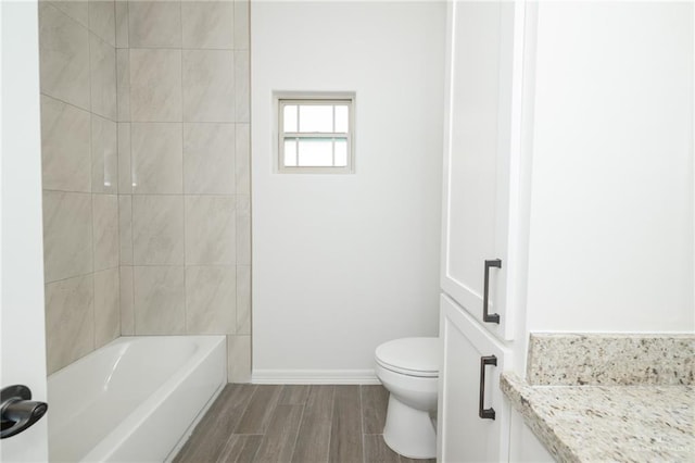 full bathroom featuring baseboards, toilet, and wood finished floors