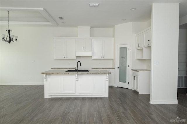 kitchen with a sink, visible vents, white cabinetry, dark wood-style floors, and an island with sink