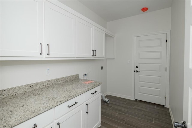 laundry area featuring cabinet space, baseboards, hookup for a washing machine, hookup for an electric dryer, and wood finish floors