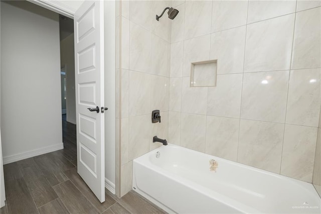 full bath with wood tiled floor, baseboards, and shower / washtub combination