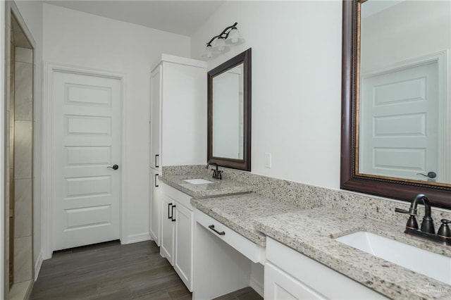 full bath with wood finished floors, a sink, and double vanity