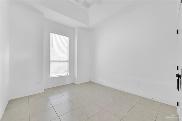 unfurnished room with light tile patterned flooring and baseboards