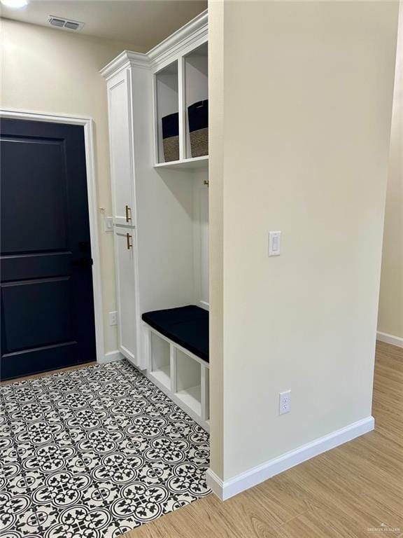 mudroom with visible vents, light wood-type flooring, and baseboards