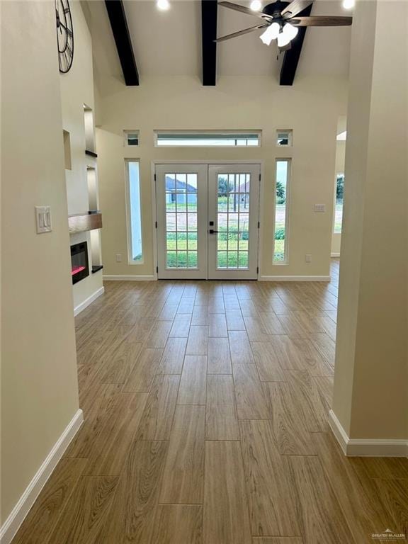 entryway with beam ceiling, baseboards, wood finished floors, and ceiling fan