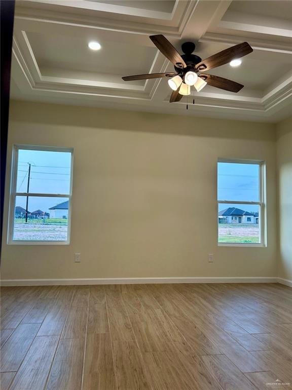 spare room with wood finished floors, a ceiling fan, coffered ceiling, and a tray ceiling