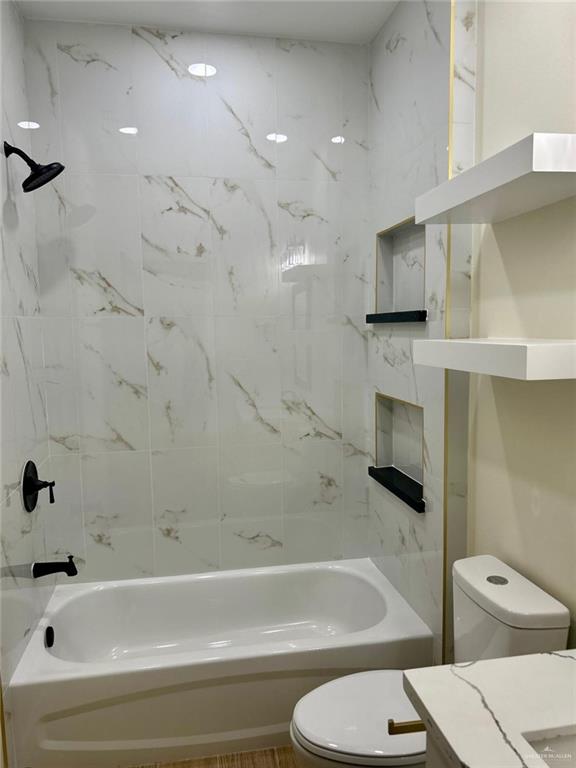 full bath featuring toilet, tub / shower combination, and vanity