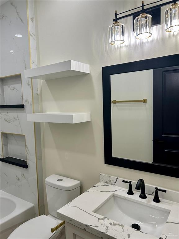 full bathroom with toilet and vanity