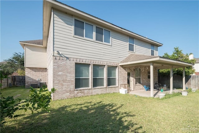 rear view of house with a yard and a patio