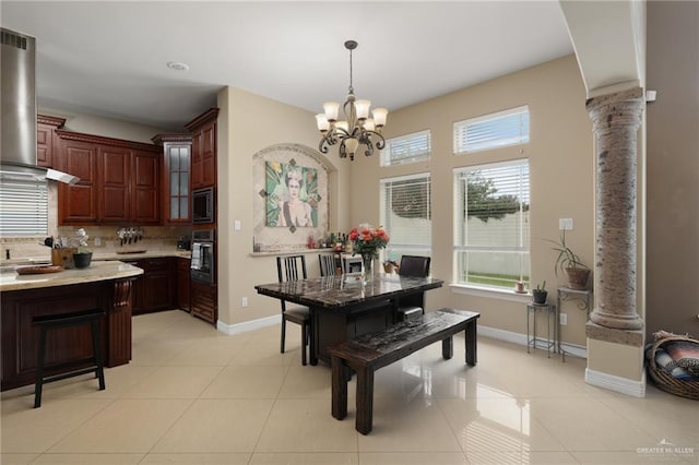 2201 W Rhin Dr, Edinburg, TX 78539 - dining area with decorative columns, a chandelier, baseboards, and light tile patterned flooring