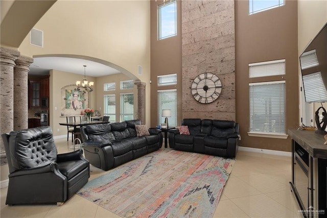 2201 W Rhin Dr, Edinburg, TX 78539 - living room with a high ceiling, ornate columns, arched walkways, baseboards, and light tile patterned floors