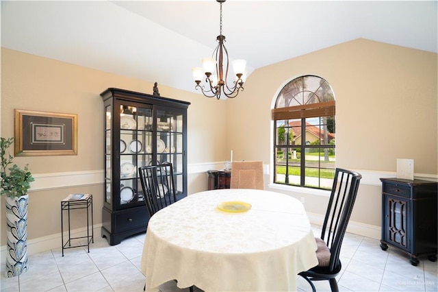 tiled dining room featuring an inviting chandelier and lofted ceiling