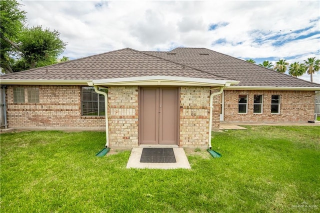 rear view of property with a yard