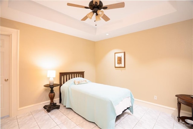 tiled bedroom featuring a tray ceiling and ceiling fan