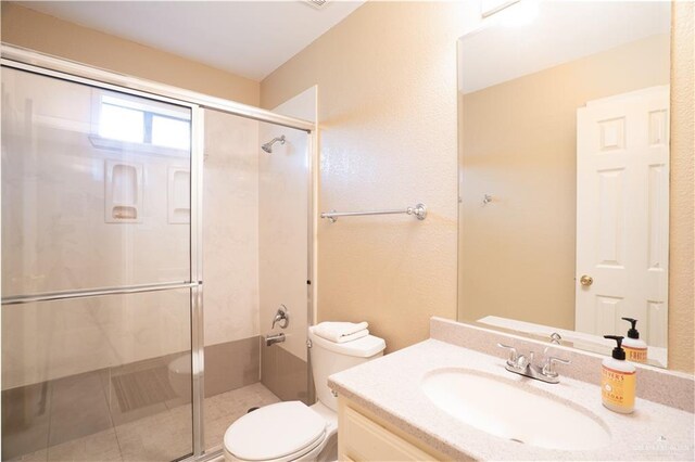 bathroom with an enclosed shower, vanity, and toilet