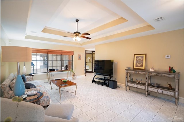 living room featuring a raised ceiling and ceiling fan