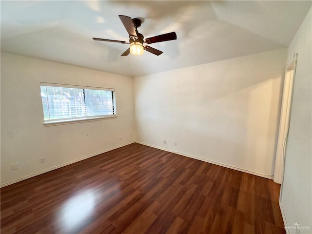 spare room featuring ceiling fan, dark wood-type flooring, and lofted ceiling