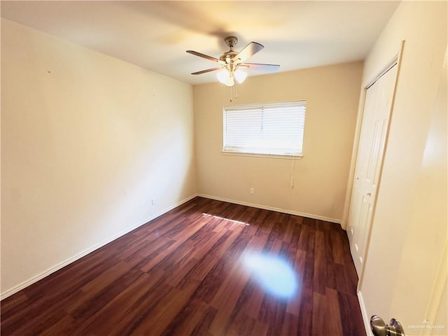 unfurnished bedroom with dark hardwood / wood-style flooring, a closet, and ceiling fan