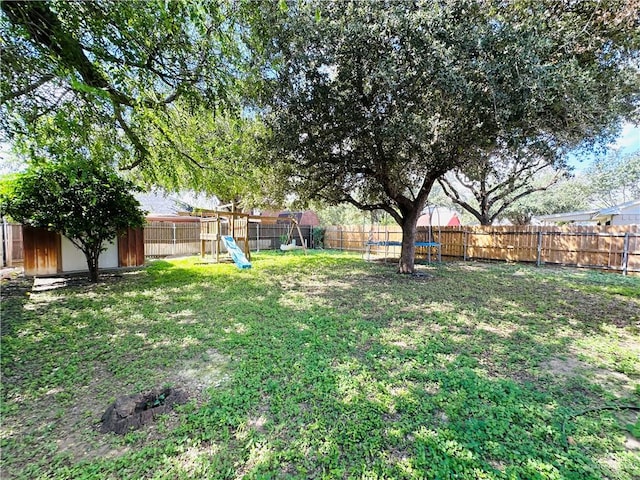 view of yard with a playground, a storage shed, and a trampoline