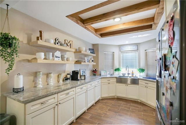 kitchen featuring open shelves, wood tiled floor, a sink, refrigerator with ice dispenser, and beamed ceiling