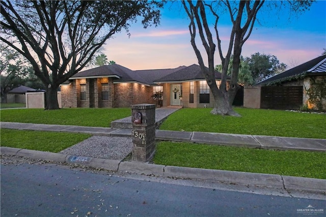 view of front of home with fence and a yard