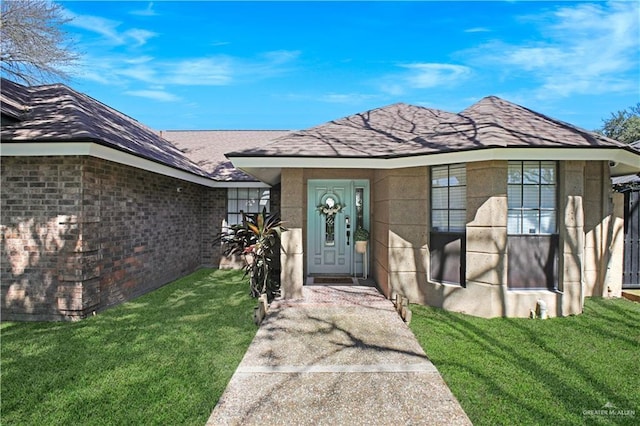 doorway to property featuring a yard and brick siding