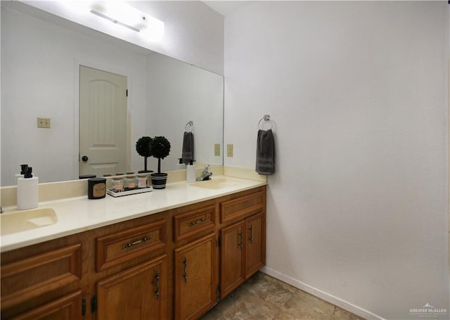 bathroom featuring a sink, baseboards, and double vanity