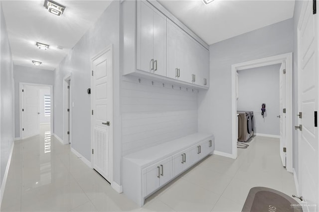 6073 Surrey Ln, Brownsville, TX 78526 - mudroom featuring washer and clothes dryer, light tile patterned floors, and baseboards