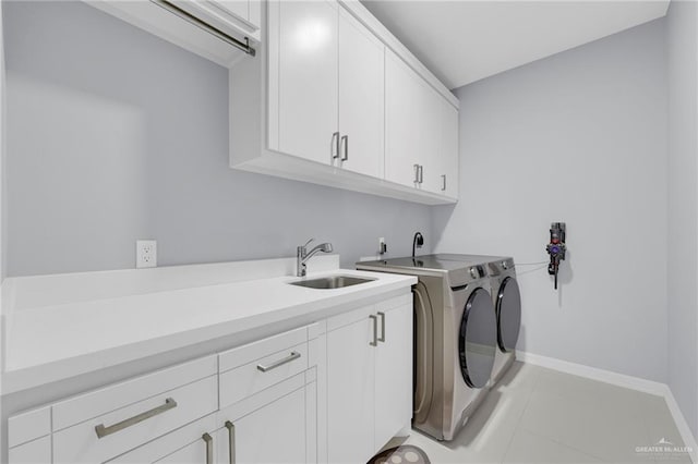 6073 Surrey Ln, Brownsville, TX 78526 - laundry area featuring cabinet space, washing machine and clothes dryer, baseboards, and light tile patterned floors