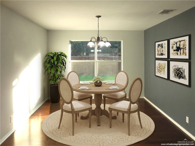 dining area with hardwood / wood-style floors and a notable chandelier