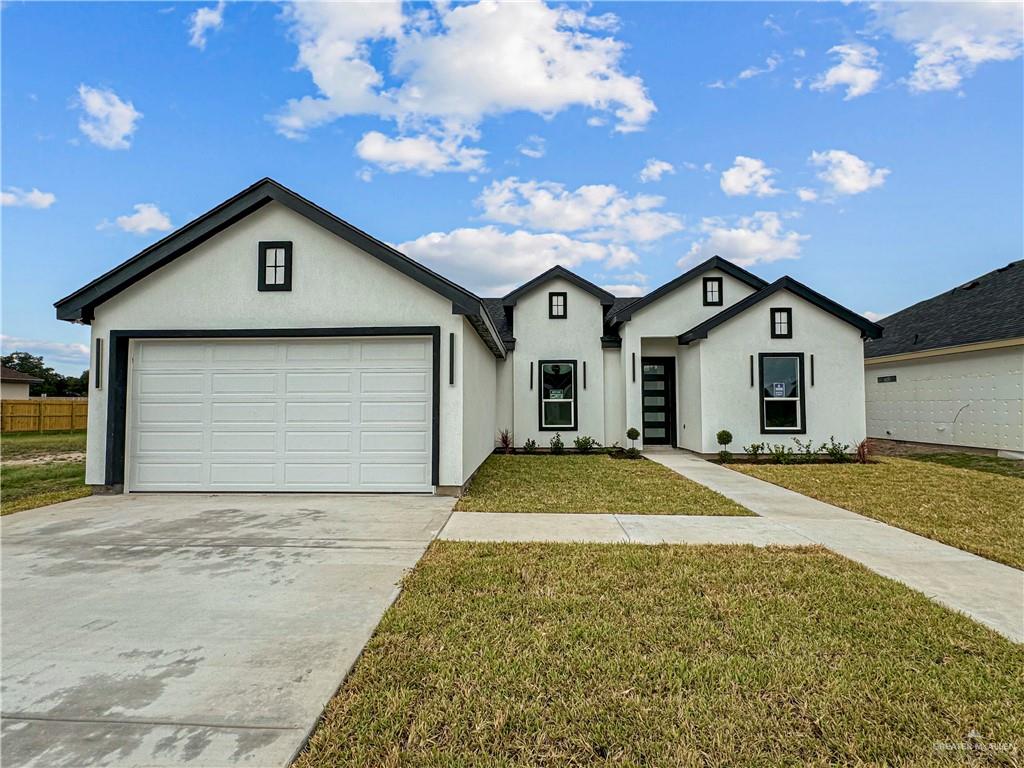 single story home featuring a garage and a front lawn