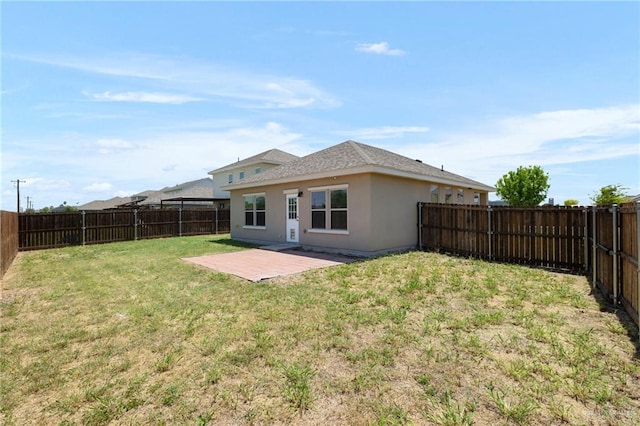 rear view of house with a lawn, a fenced backyard, and a patio area