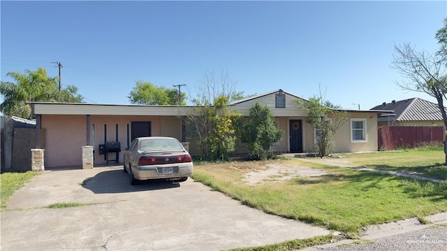 ranch-style home featuring concrete driveway, fence, a front lawn, and stucco siding