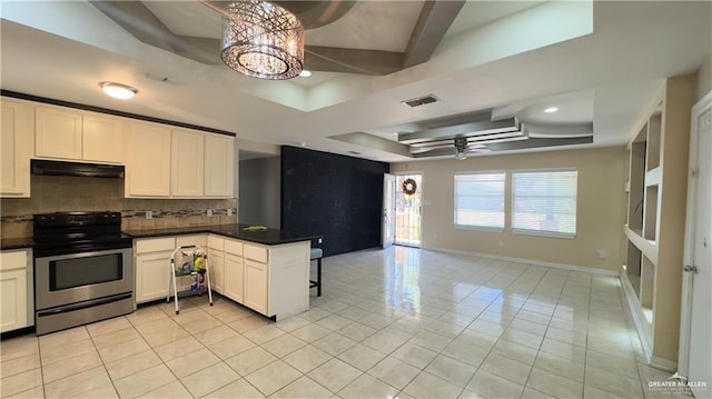 kitchen with visible vents, stainless steel electric range, a tray ceiling, and open floor plan