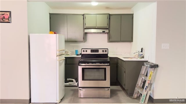 kitchen featuring freestanding refrigerator, under cabinet range hood, light countertops, stainless steel range with electric stovetop, and green cabinets