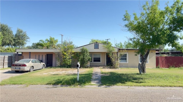 ranch-style home featuring stucco siding, fence, concrete driveway, and a front yard