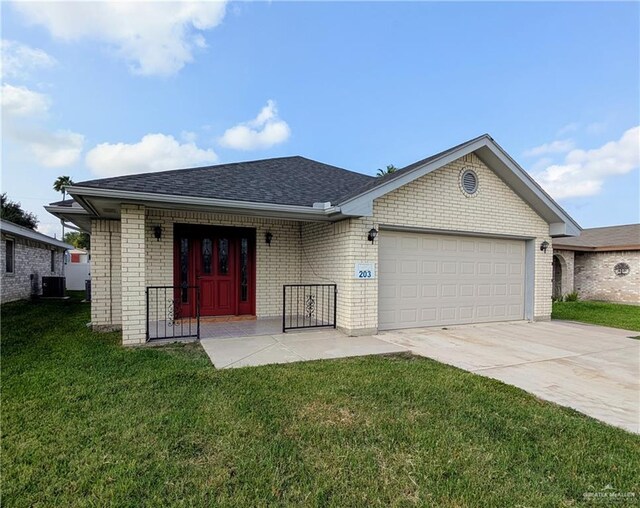 single story home featuring an attached garage, driveway, central AC unit, and a front yard